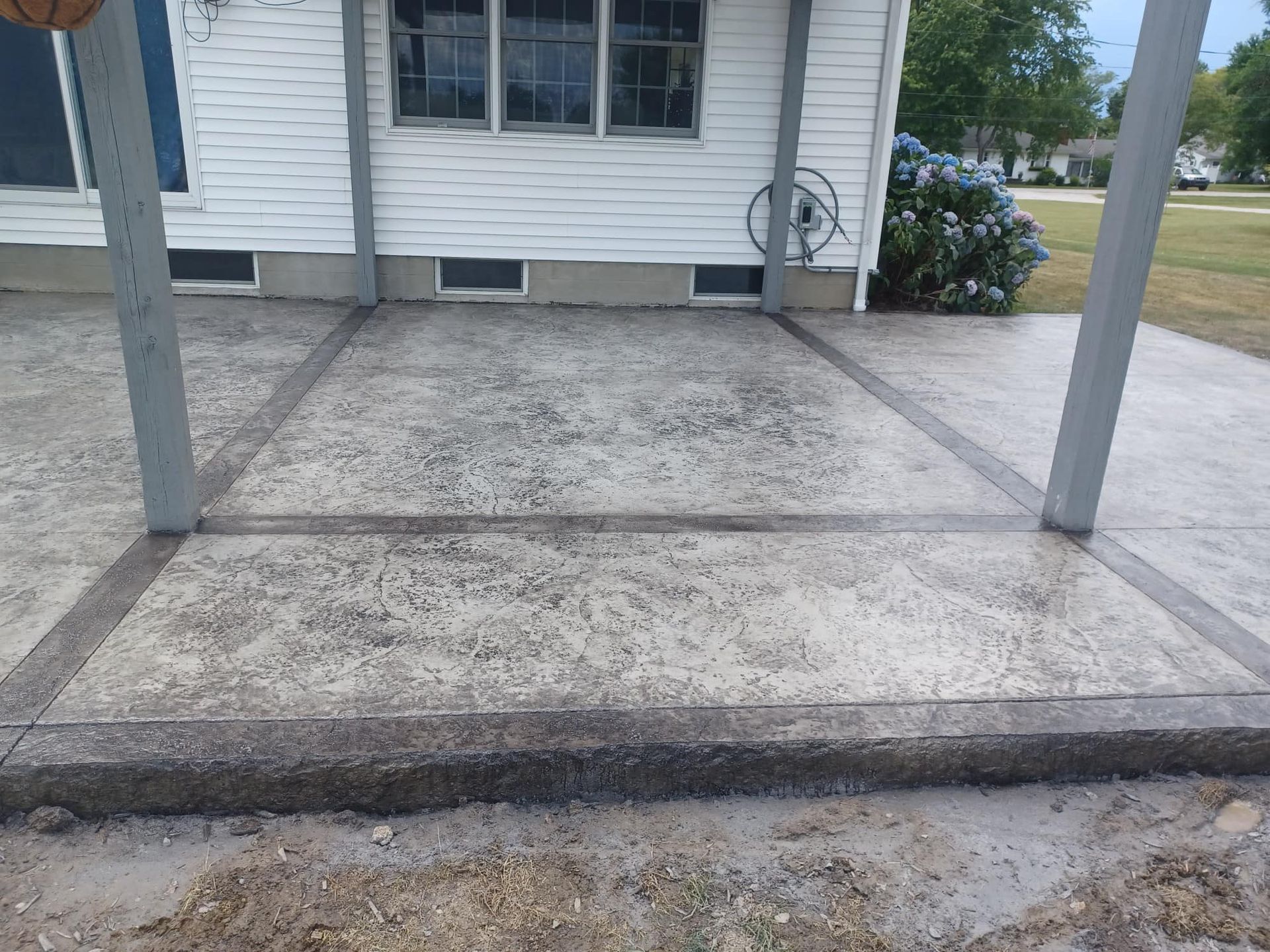 A concrete driveway in front of a white house