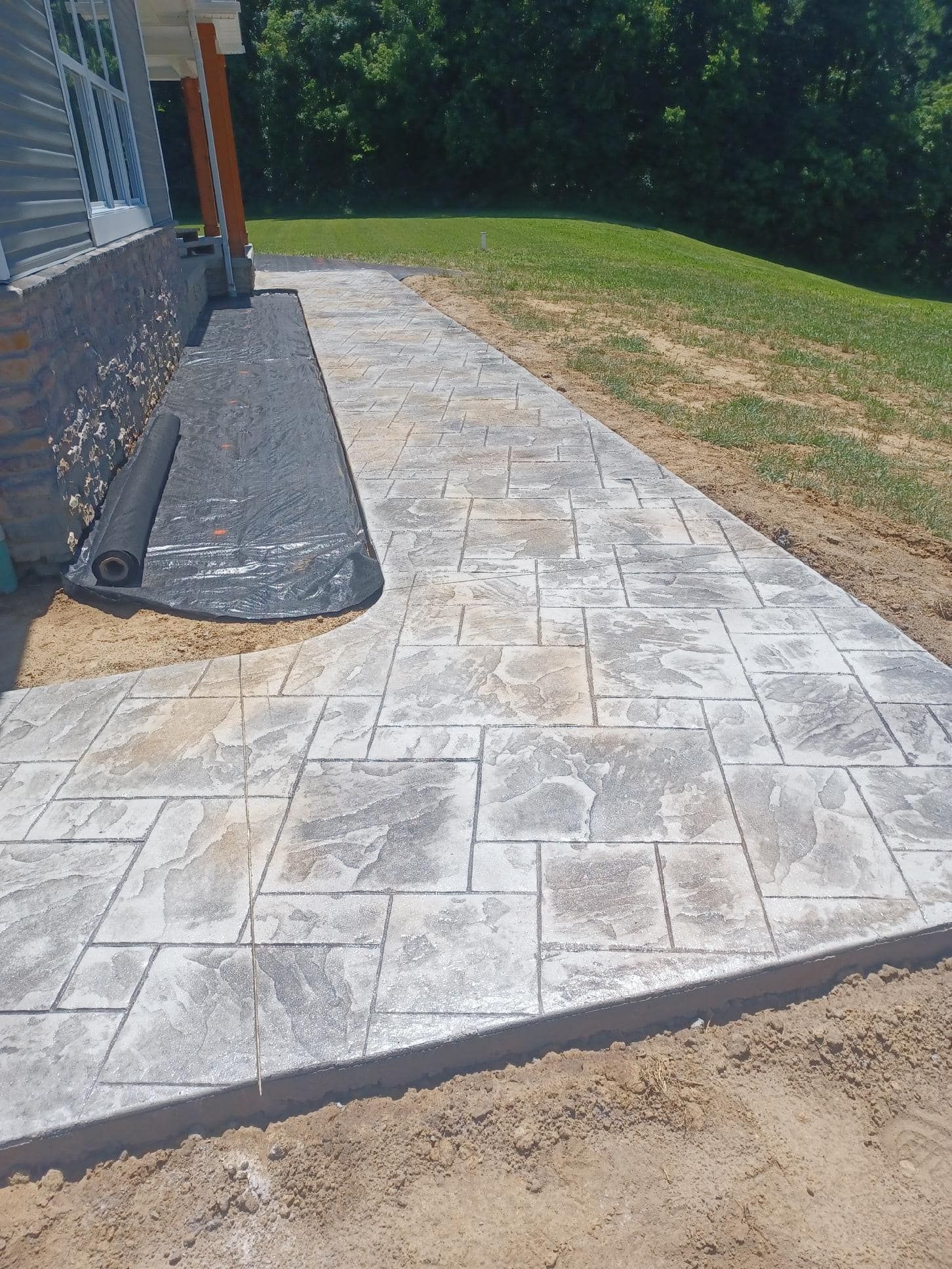 A concrete walkway is being built in front of a house.