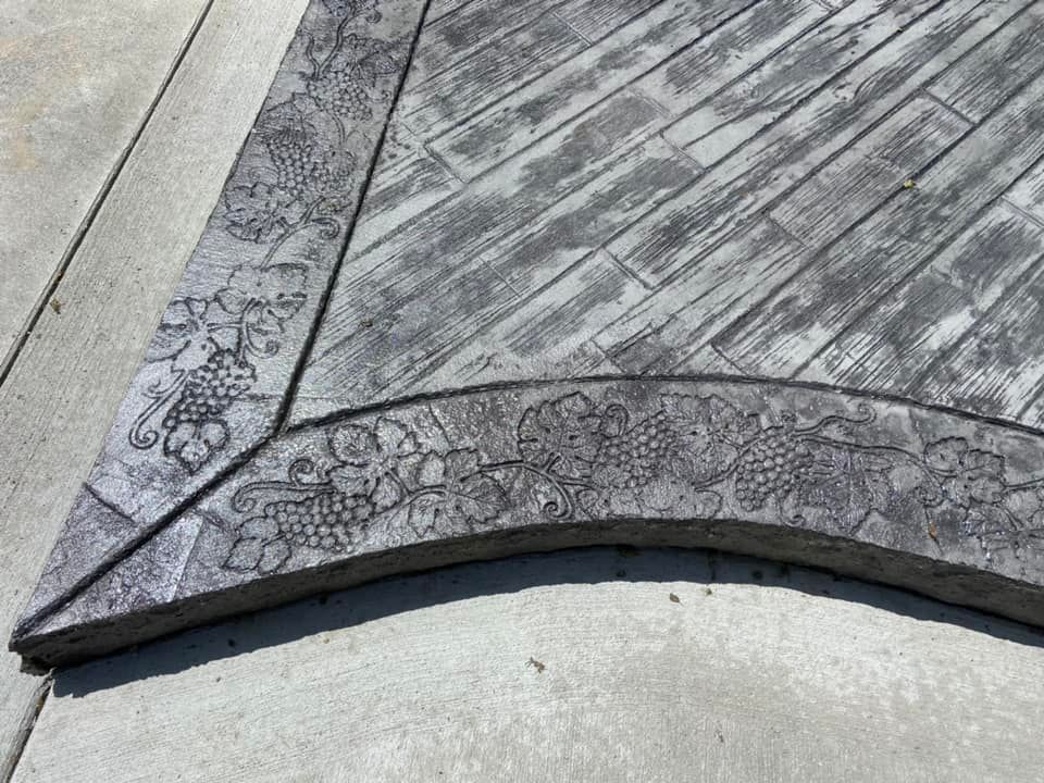 A close up of a concrete walkway with a floral design on it.