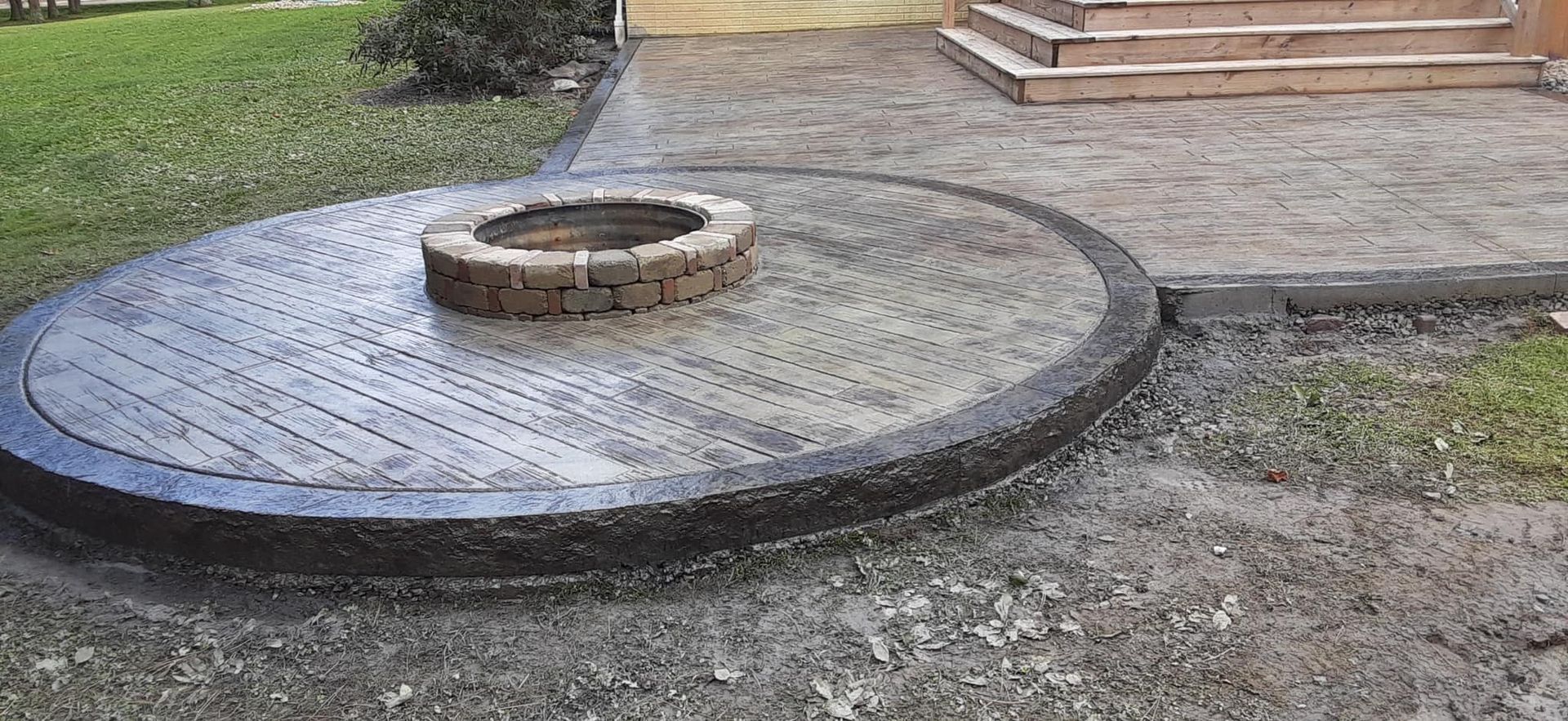 A fire pit is sitting in the middle of a concrete circle.