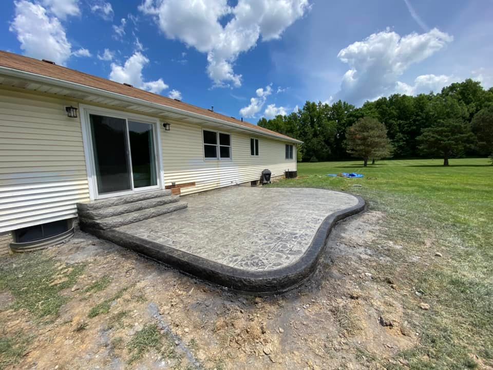 A concrete patio is being built in front of a house.