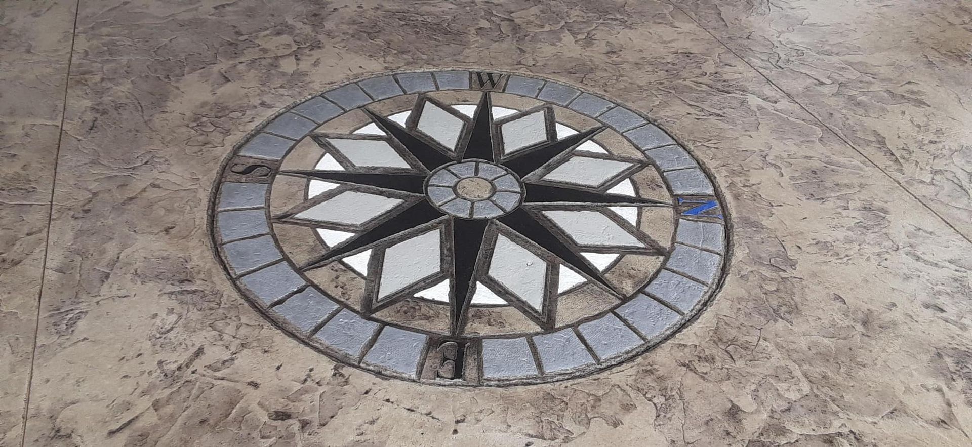 A compass rose is painted on a concrete floor.