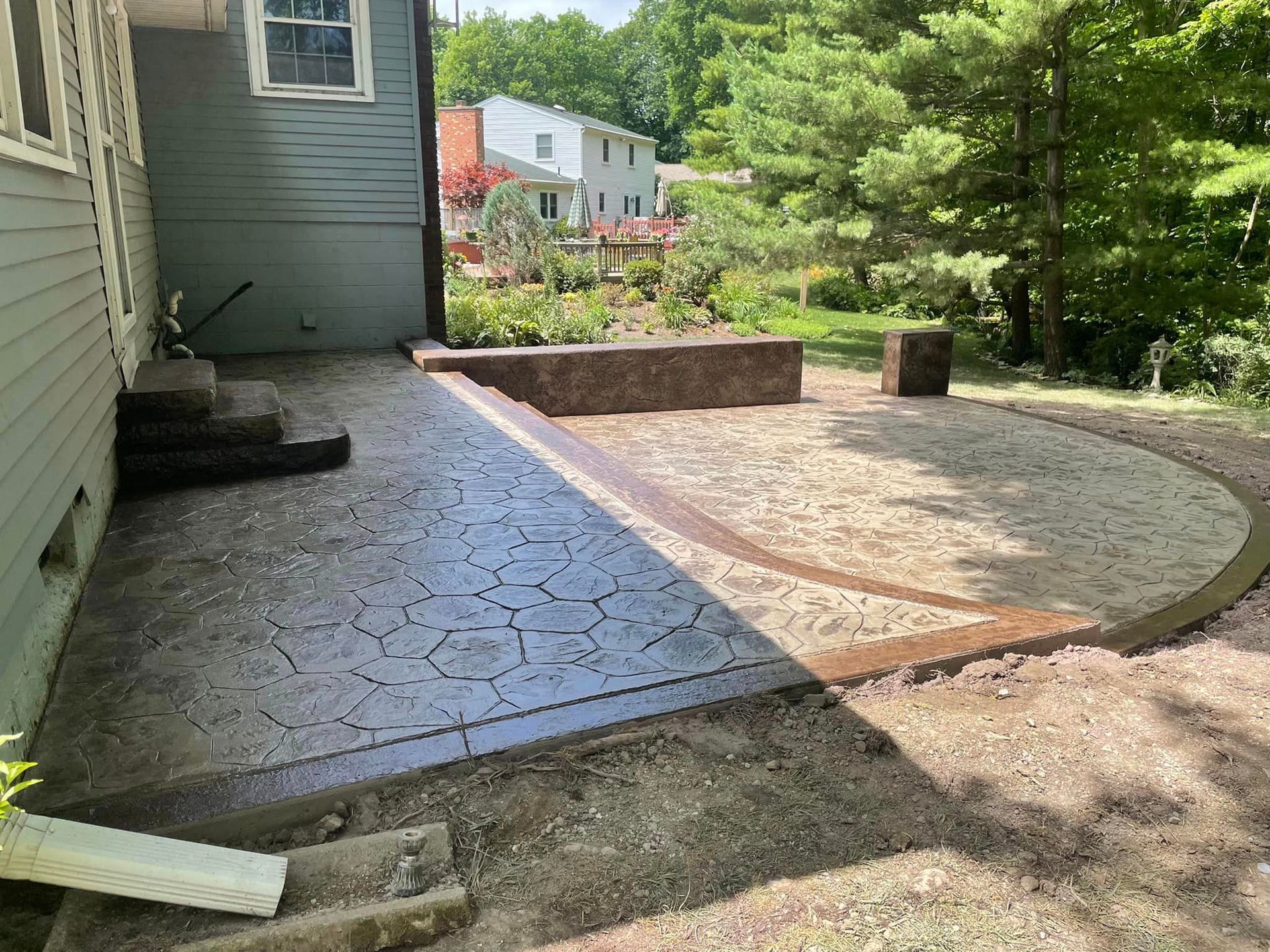 A concrete patio is being built in front of a house.