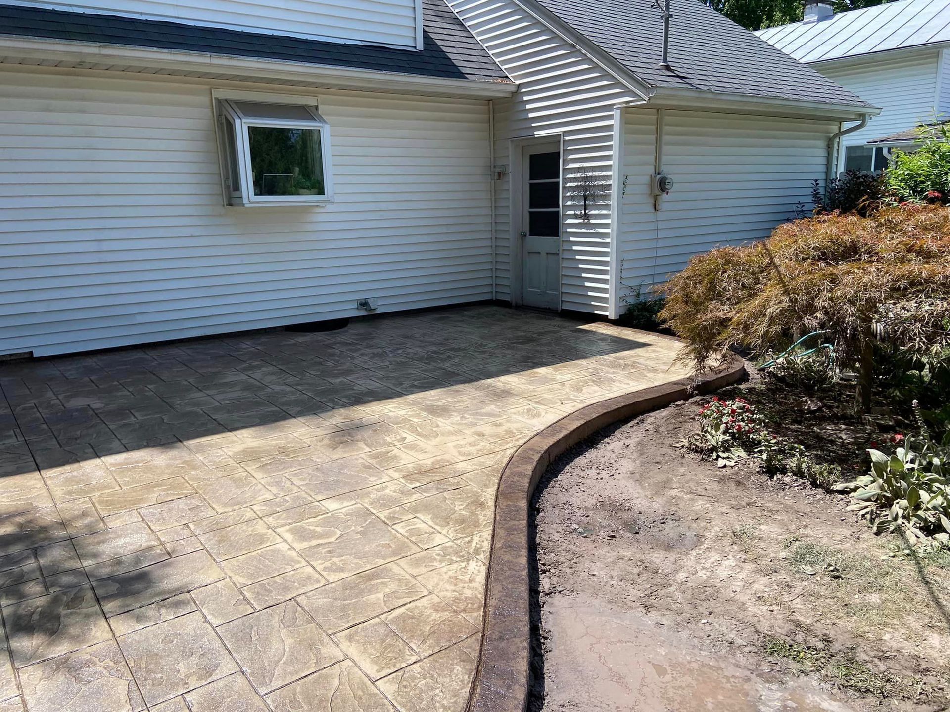 A white house with a patio in front of it.