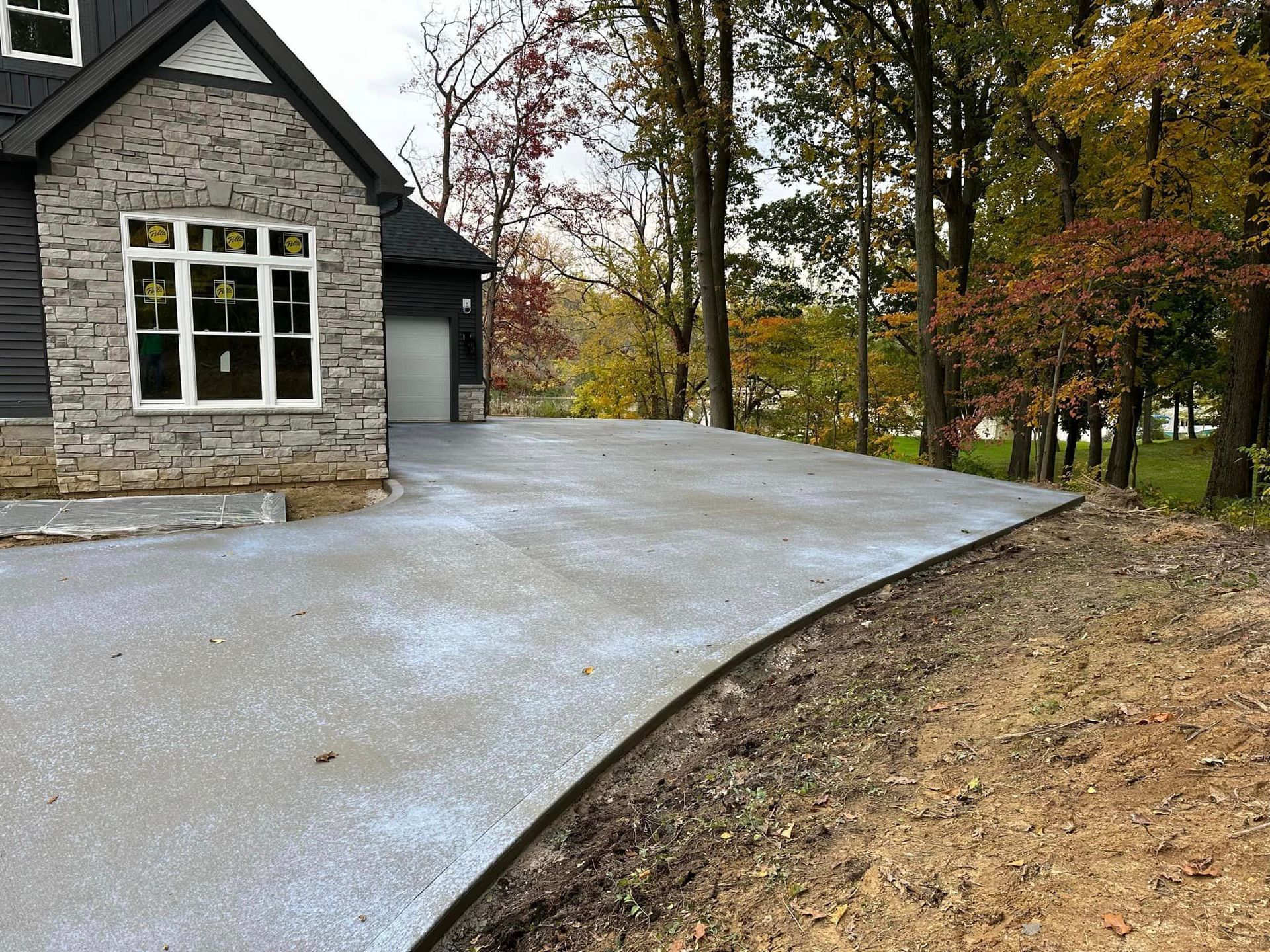A driveway leading to a house with trees in the background.