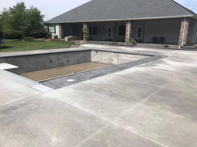 A swimming pool is being built in front of a house.