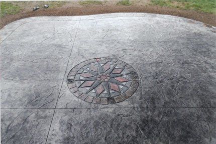 A concrete patio with a compass on it.