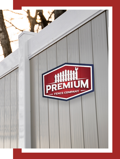 A white fence with a red sign that says premium fence company