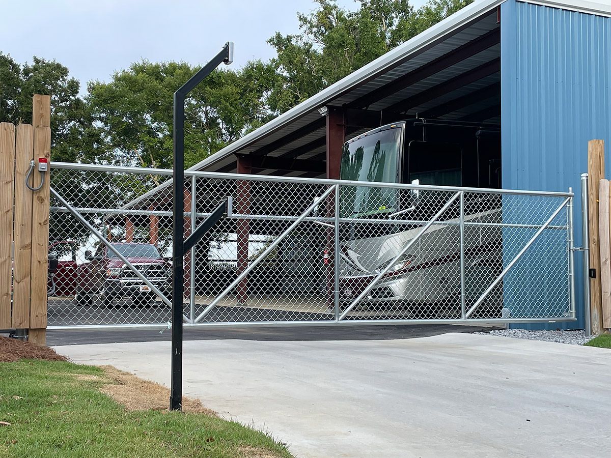 A chain link fence with a car parked in front of it.