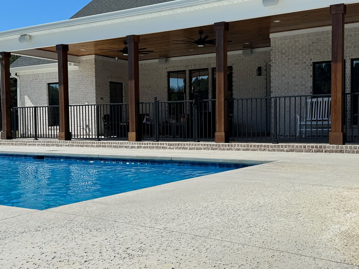 There is a large swimming pool in front of a house.