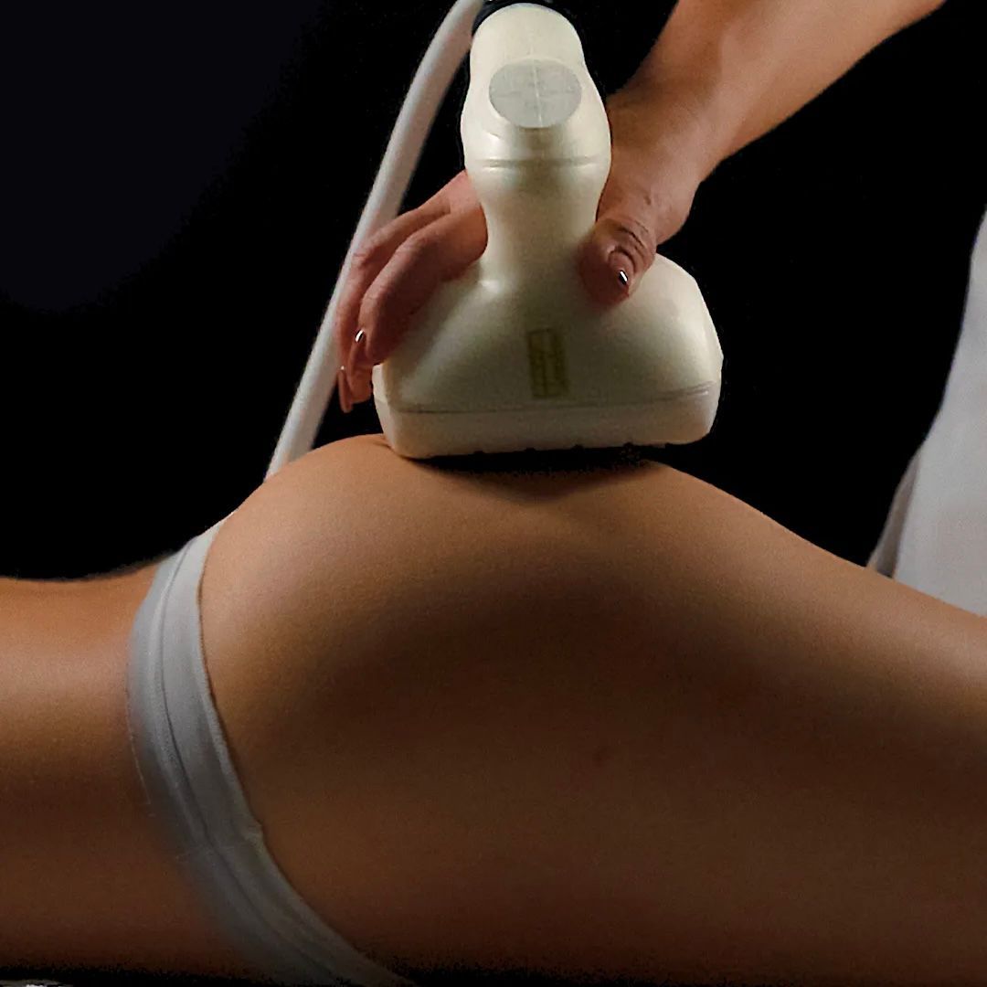 Person receiving an Artemis T-Shape 2 buttock treatment with a handheld device, in a spa setting.