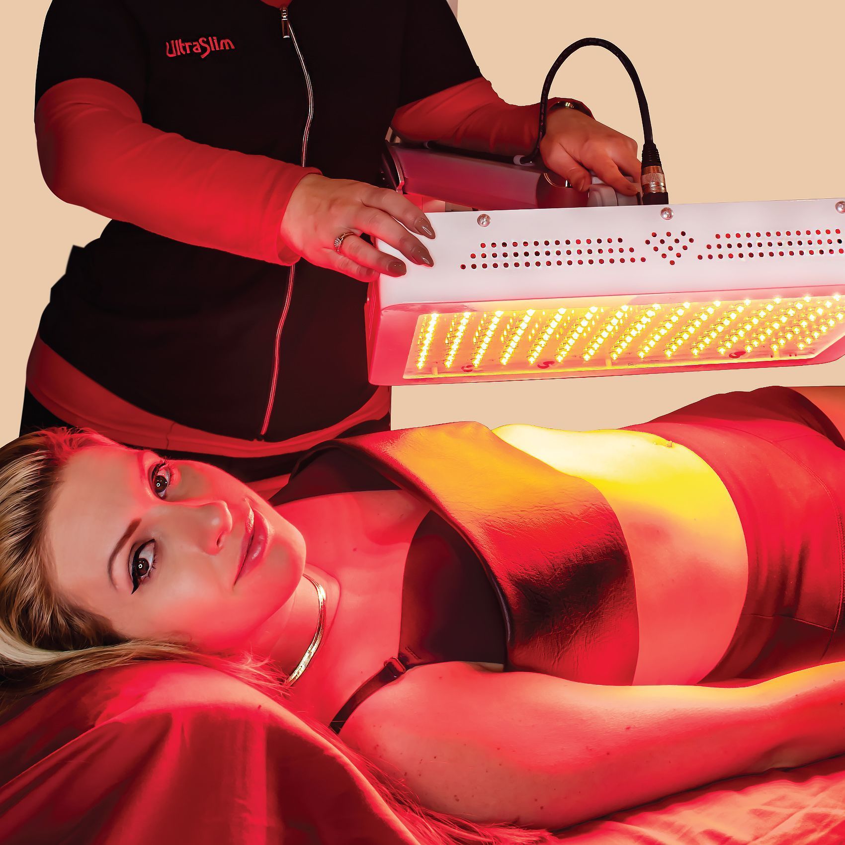 Woman receiving red light therapy treatment; device held by a person.