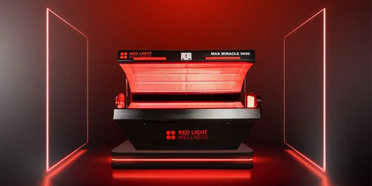 Red light therapy machine in a red-lit room with neon-framed walls.
