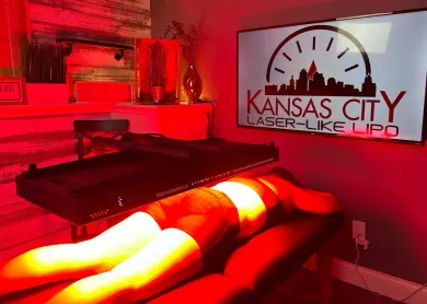 Woman undergoing a laser treatment at Kansas City Laser-Like Lipo. Red light illuminates the treatment area.