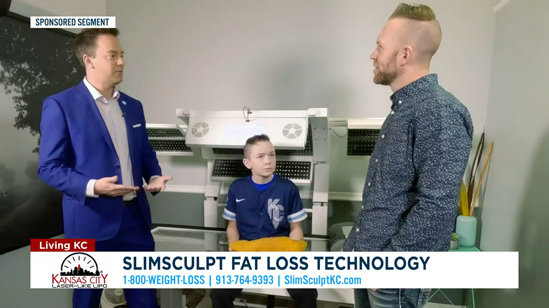 Three people in front of a machine labeled 