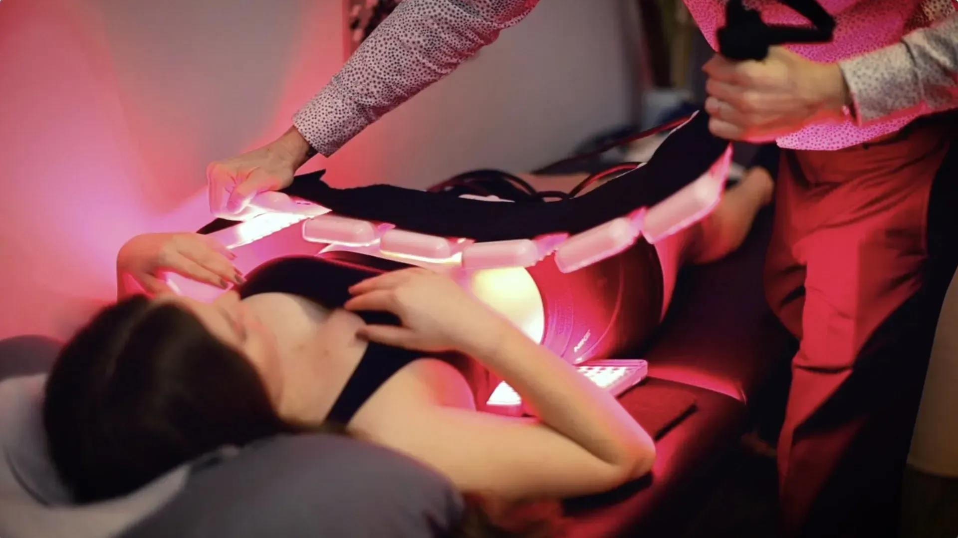 Person receiving red light therapy treatment while lying down.