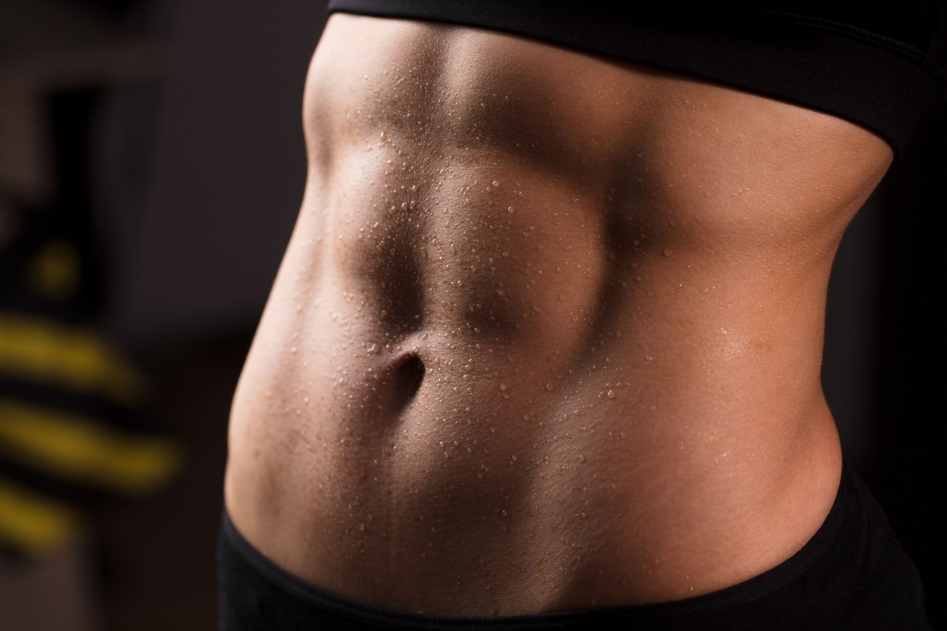 Sweaty, toned abdomen, side view, showing defined abdominal muscles.