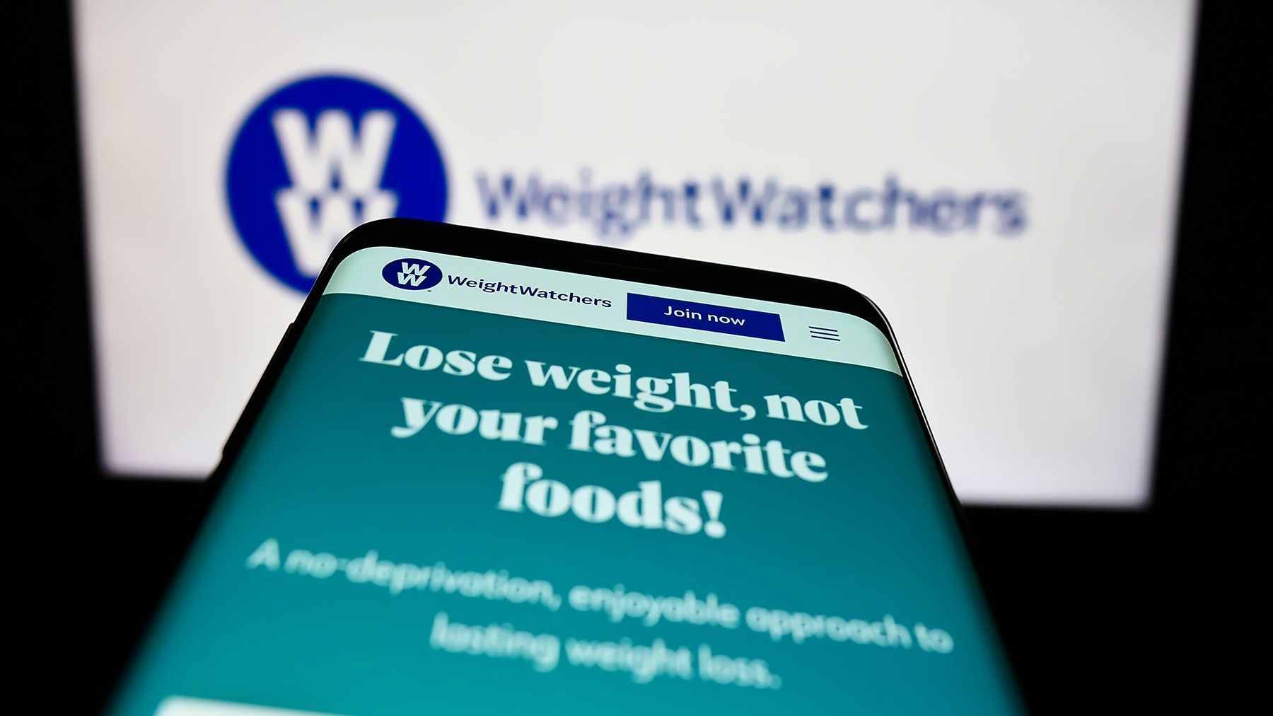 Smartphone displaying Weight Watchers website with the tagline 