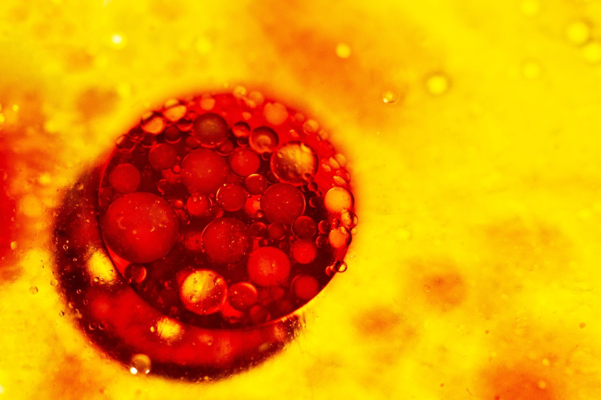 Red and yellow abstract of oil and water, with a large, vibrant red circle containing smaller circles on yellow background.