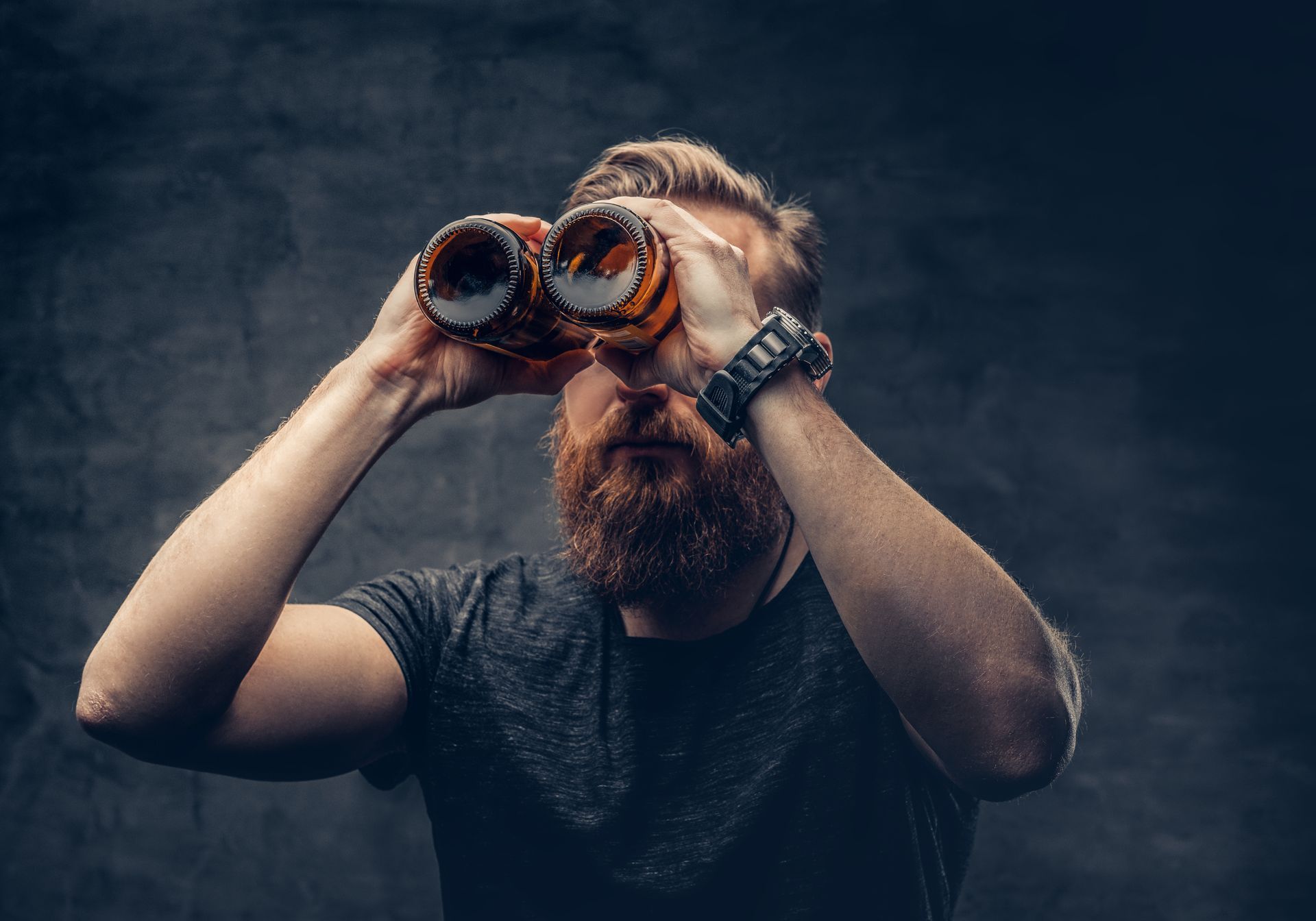 Man with red beard looking through binoculars.