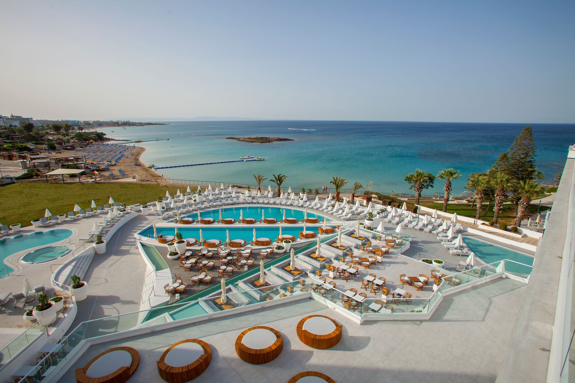 King Jason Protaras with pools overlooking Fig Tree Bay under a clear sky.