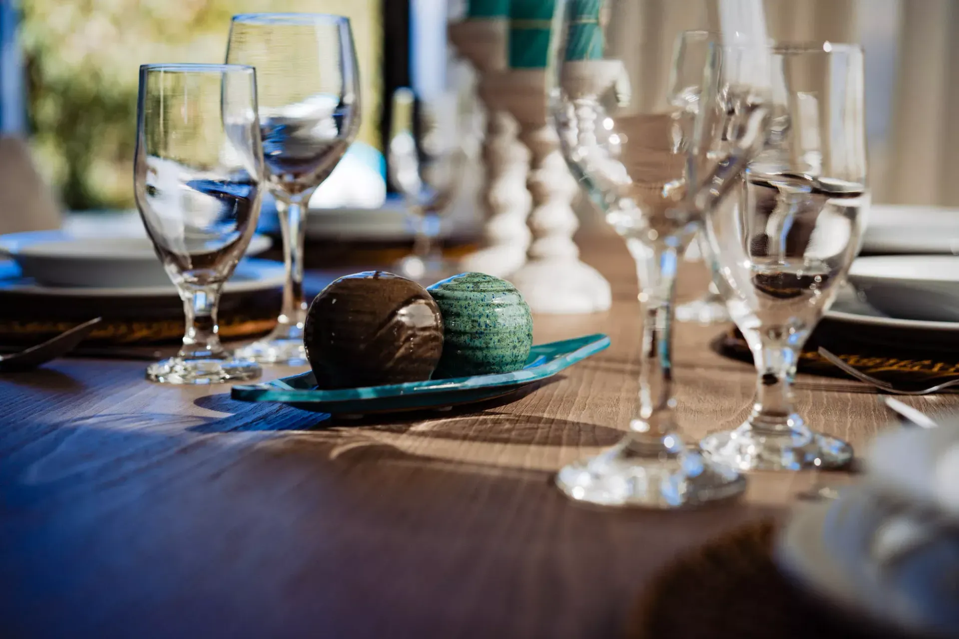 A table set for a dinner party with wine glasses and plates.