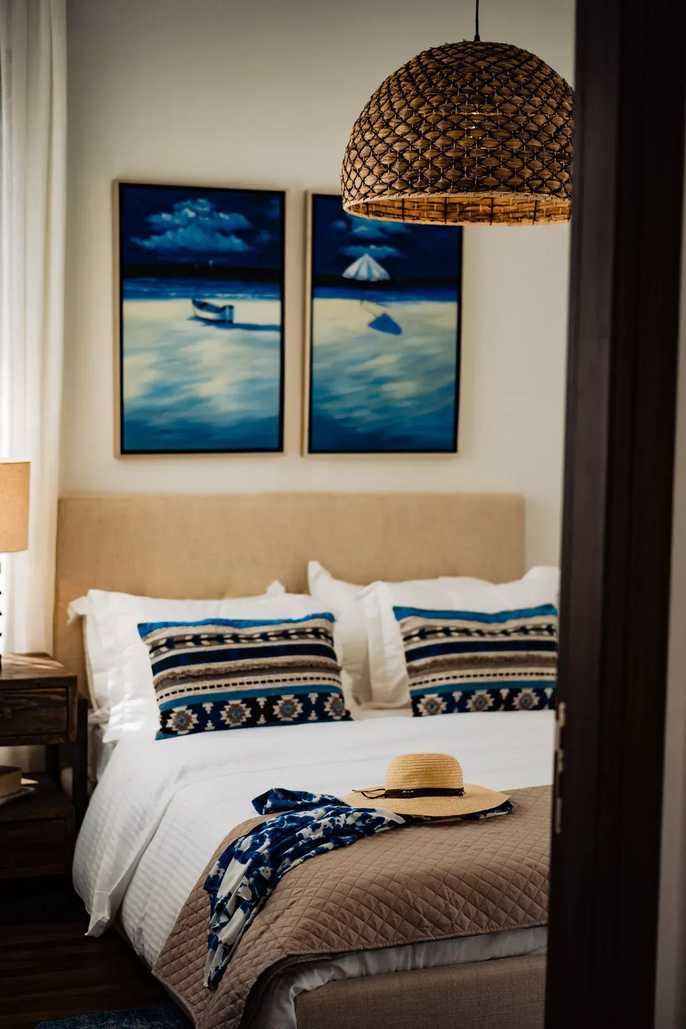 There are two paintings on the wall above the bed.