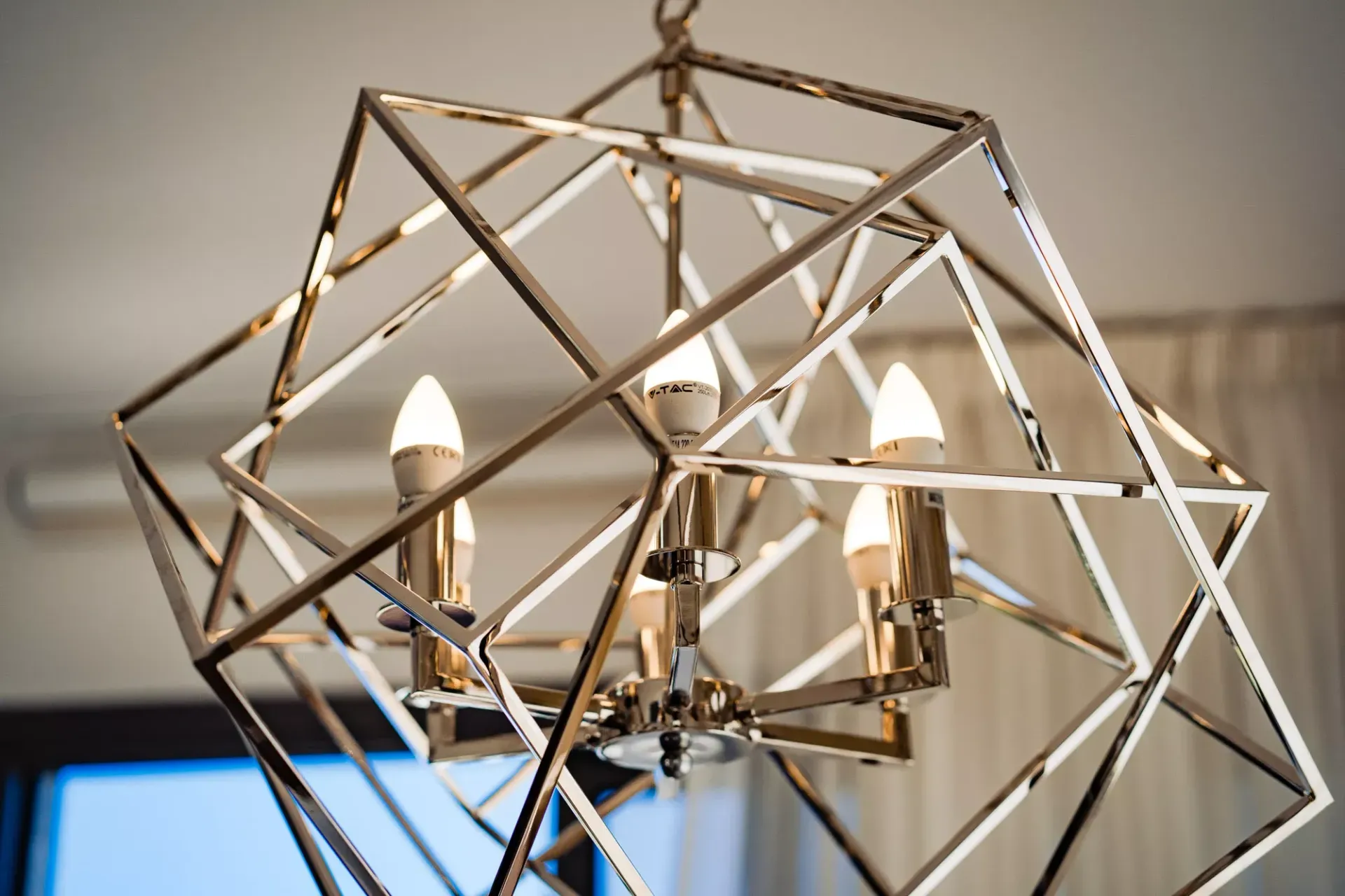 A chandelier with candles hanging from the ceiling in a room.