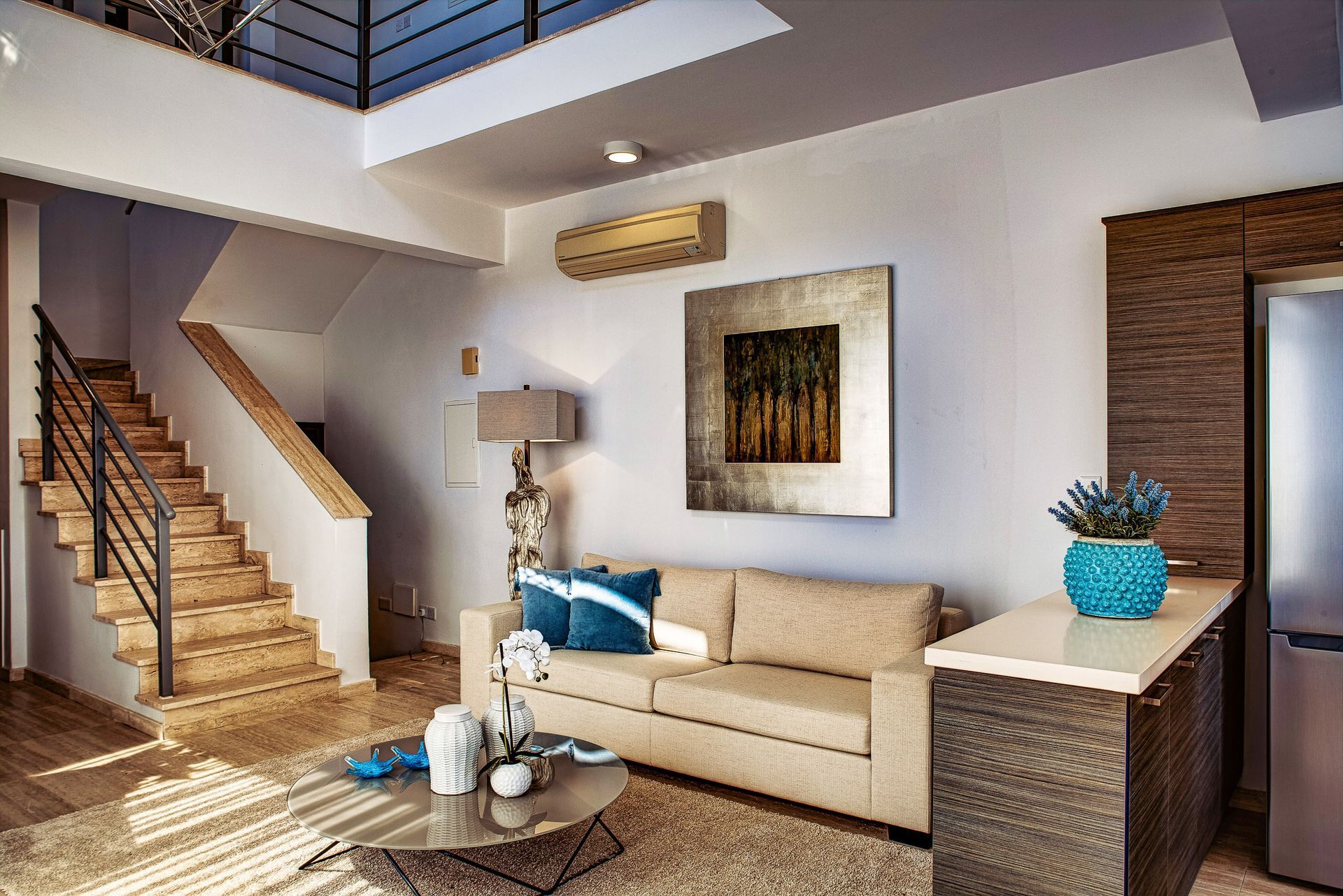 A living room with a couch , coffee table , and stairs.
