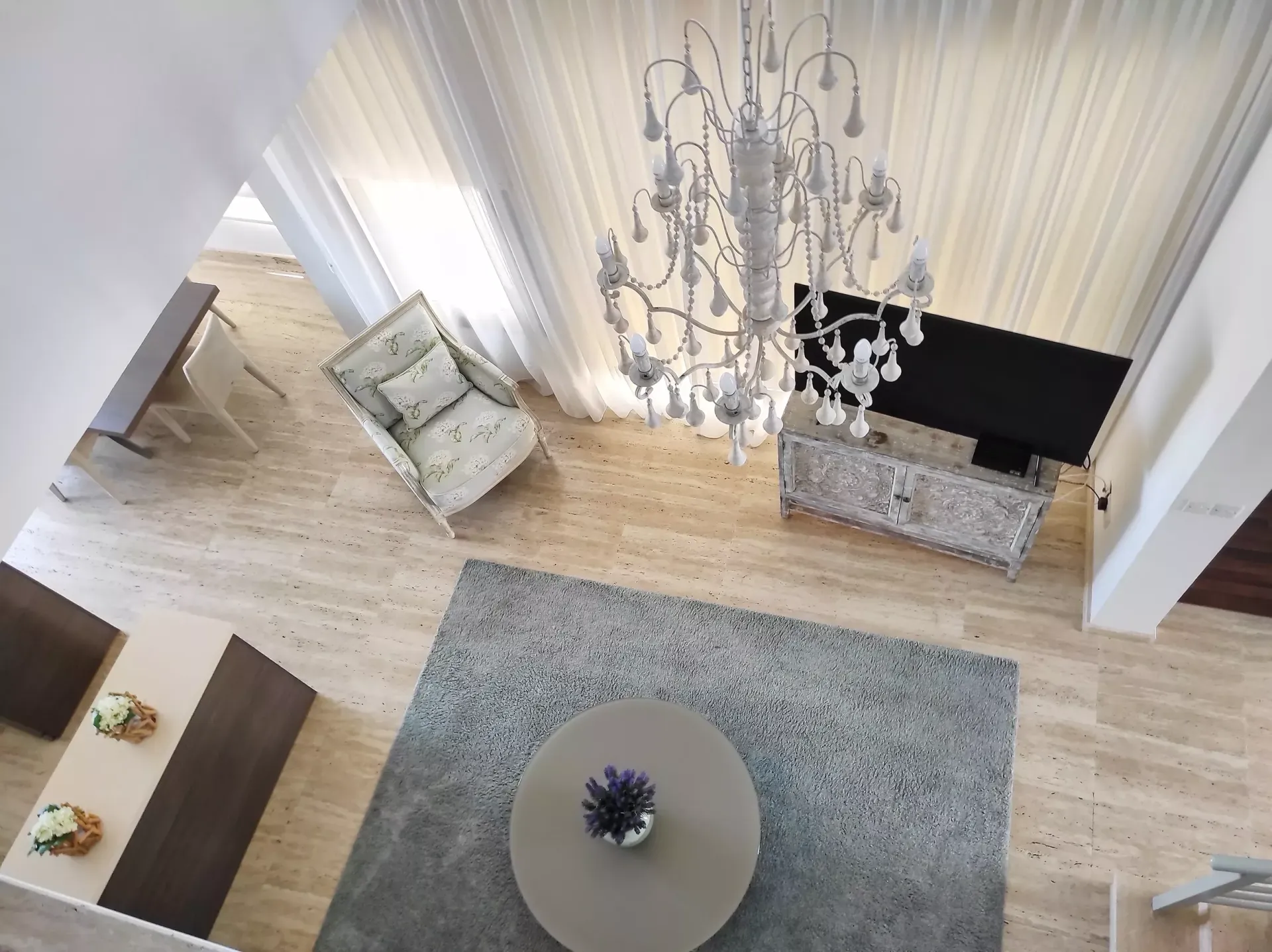 An aerial view of a living room with a chandelier hanging from the ceiling