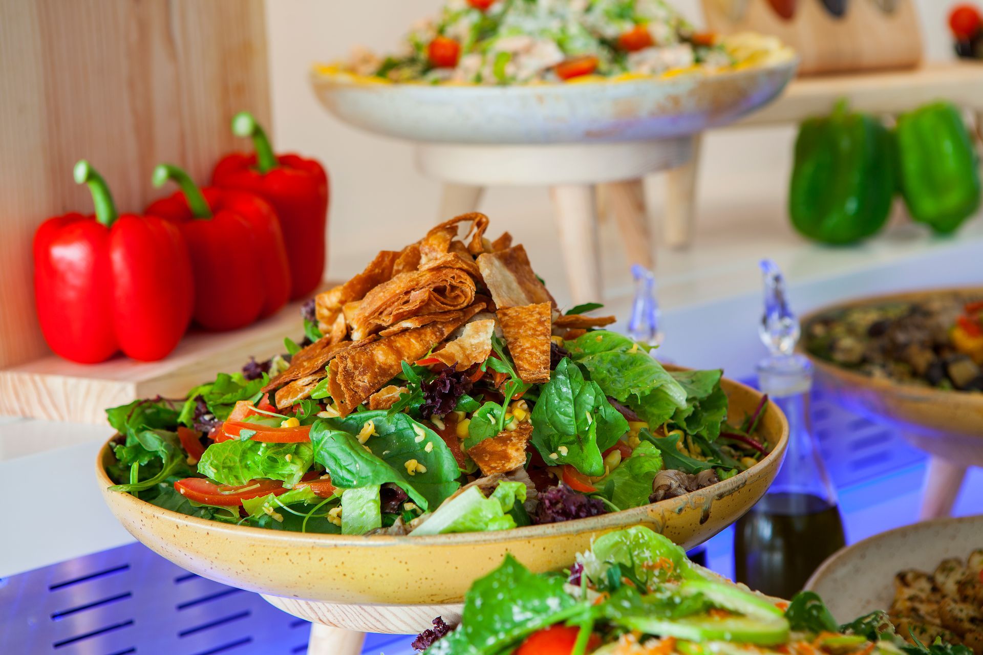 Salad buffet with multiple salads, red and green peppers, and a bottle of oil at King Jason Protaras.