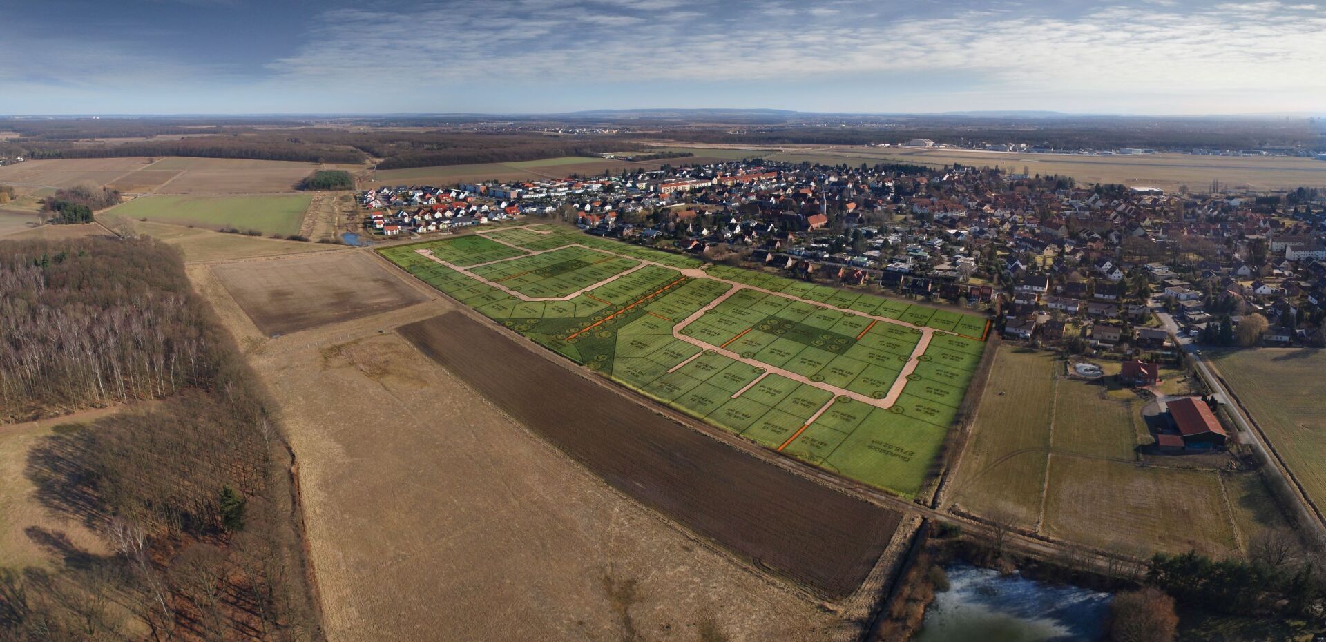 Eine Luftaufnahme eines Wohngebiets, umgeben von Feldern und Bäumen.