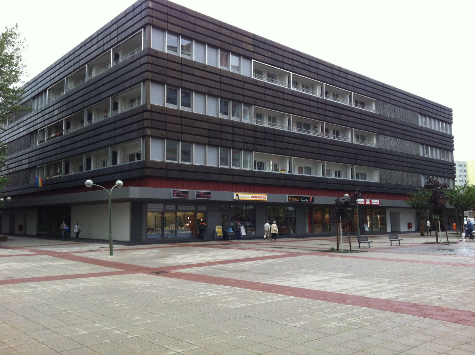 Ein großes Gebäude mit vielen Fenstern und Menschen, die davor gehen