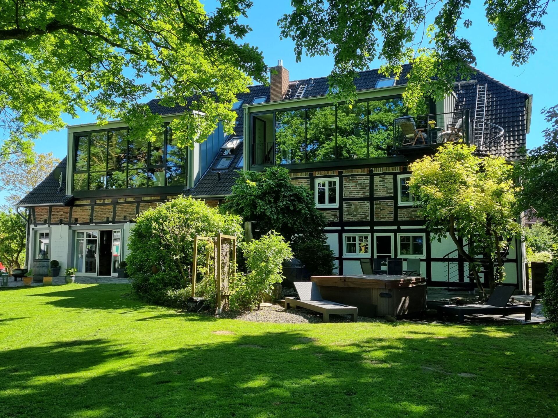 Ein großes Haus mit vielen Fenstern ist von Bäumen umgeben