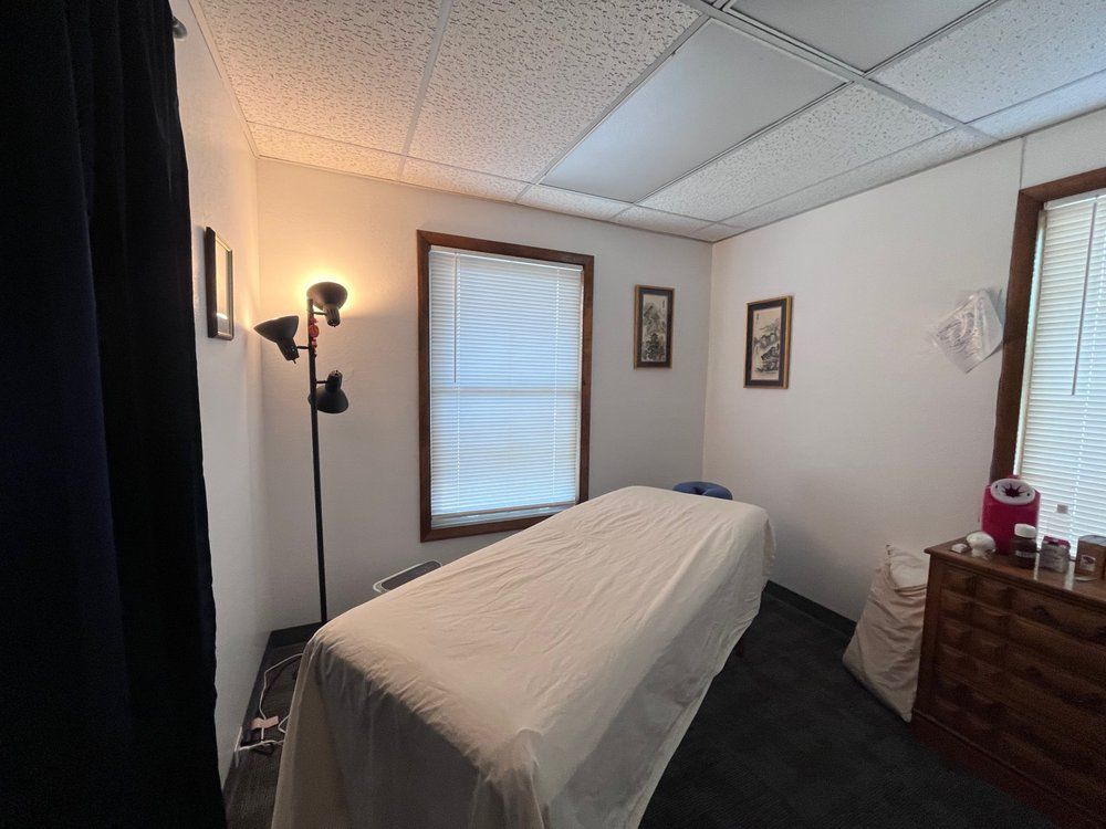 Person measuring their waist with a red and white measuring tape. They wear a camo crop top and black leggings.