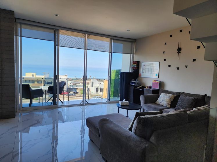 A bright living room with tile floors, a sectional sofa, a coffee table for Ibogaine treatment