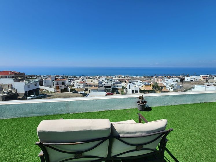 A rooftop terrace with artificial turf, a white couch for Ibogaine treatment