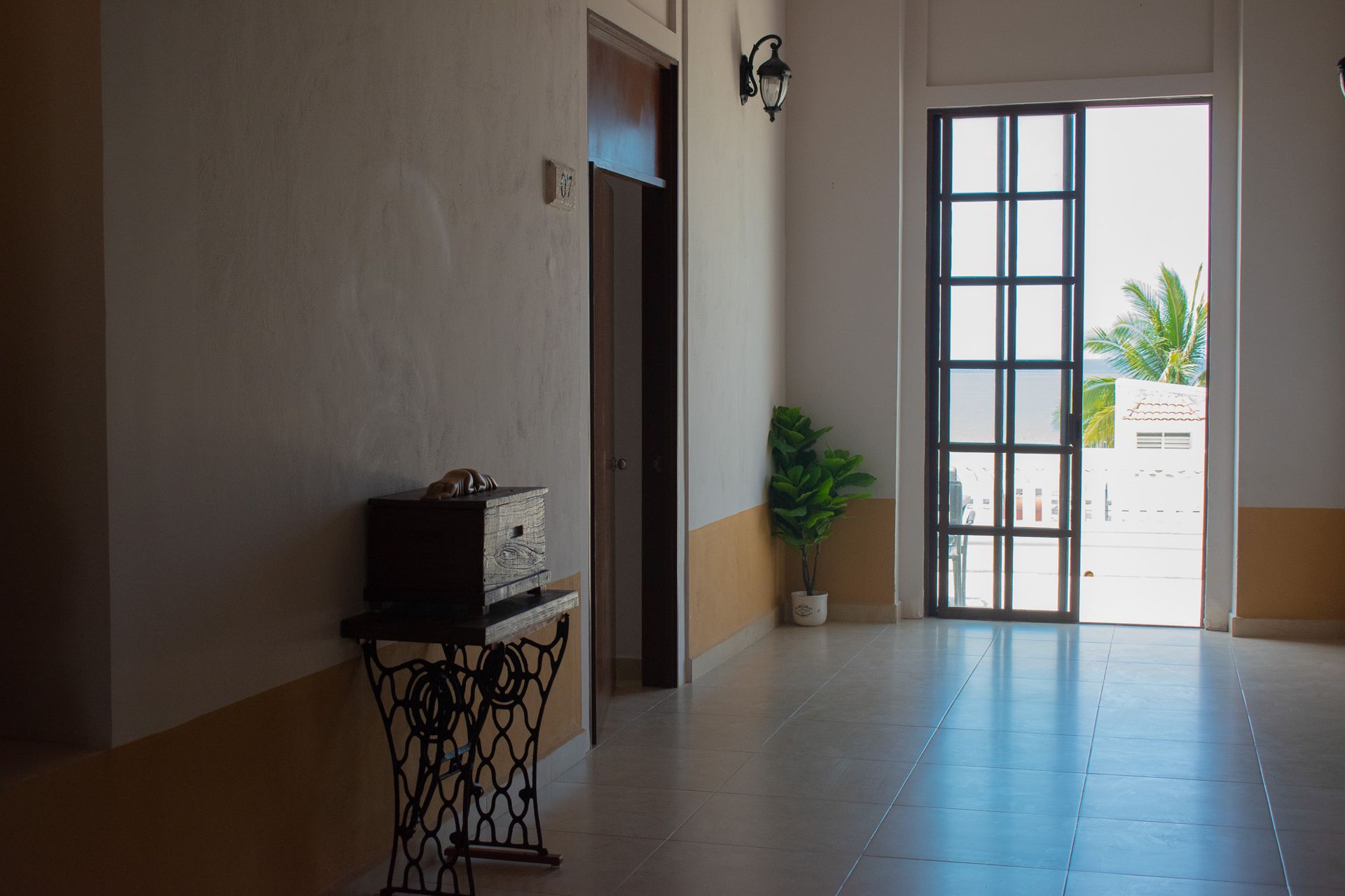 Un pasillo vacío con una mesa y una ventana.