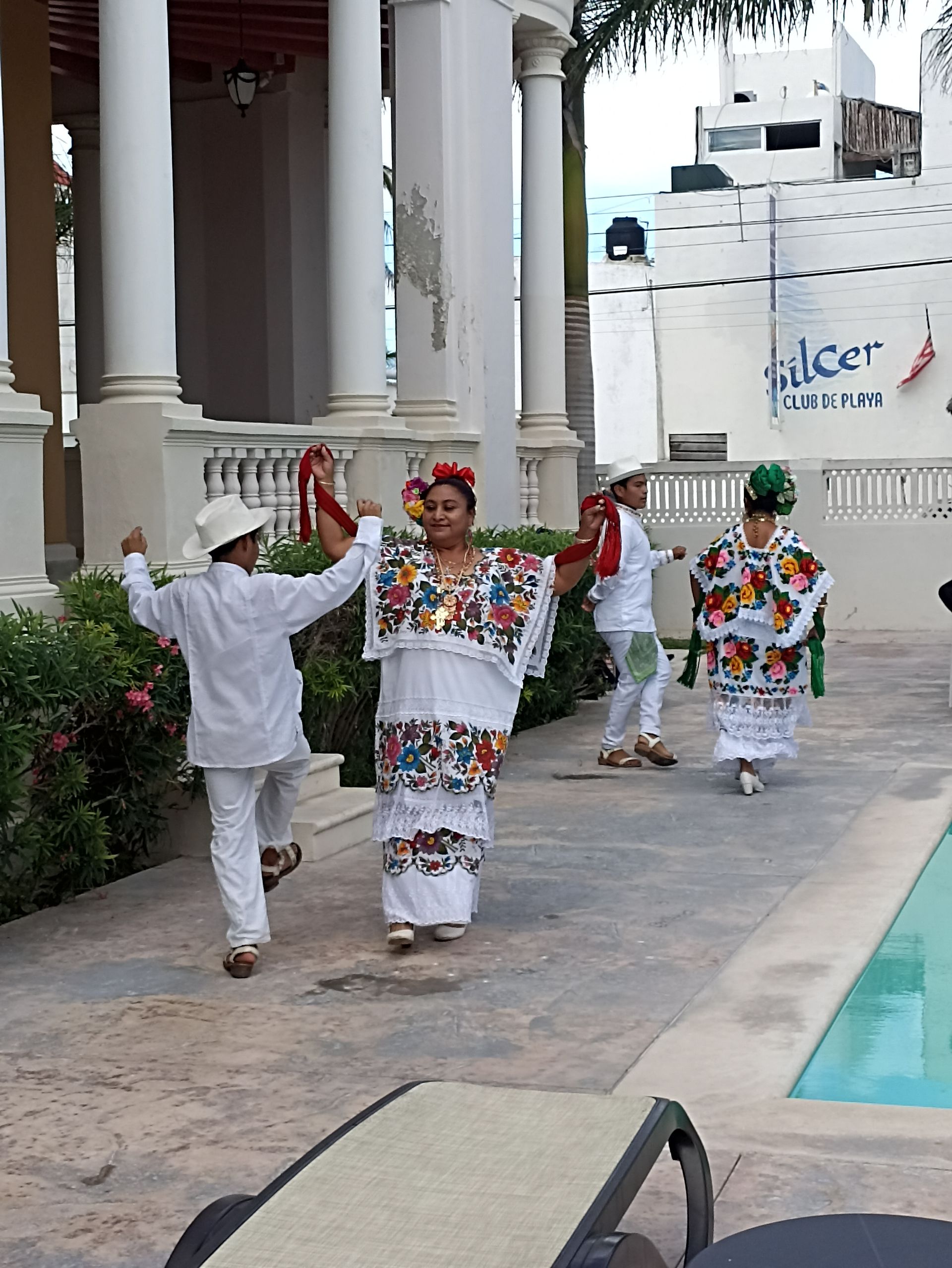 Un grupo de personas está bailando frente a un edificio que dice agradable.