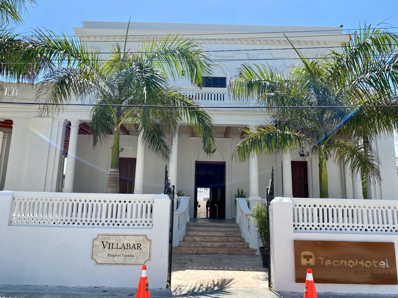 Un gran edificio blanco con palmeras delante.