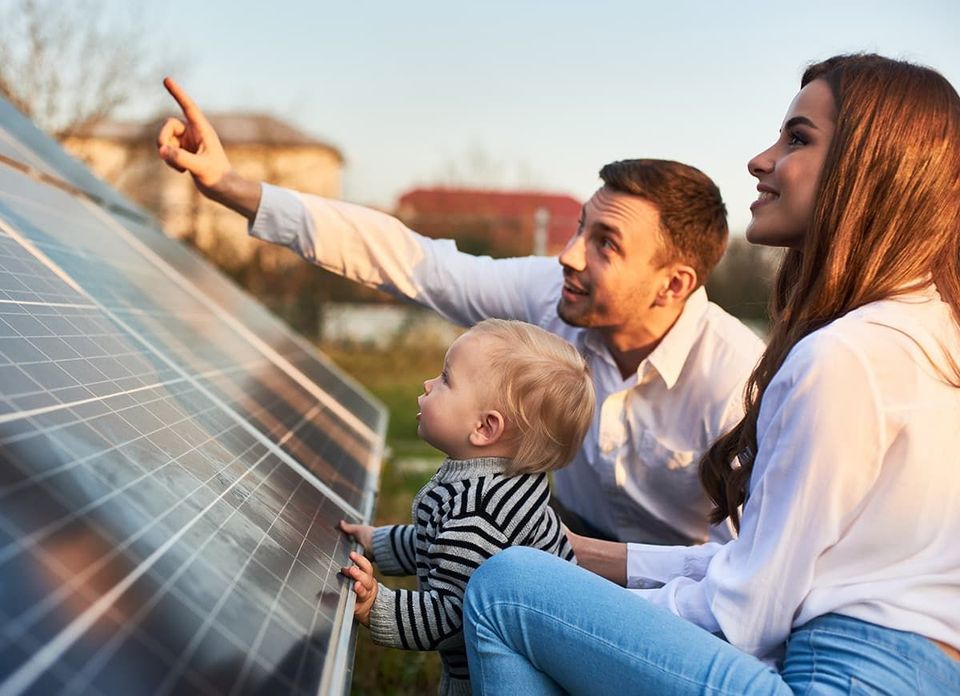 A family is looking at a solar panel together.