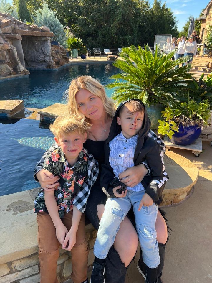 A living room with a couch , chairs , and lots of windows.
