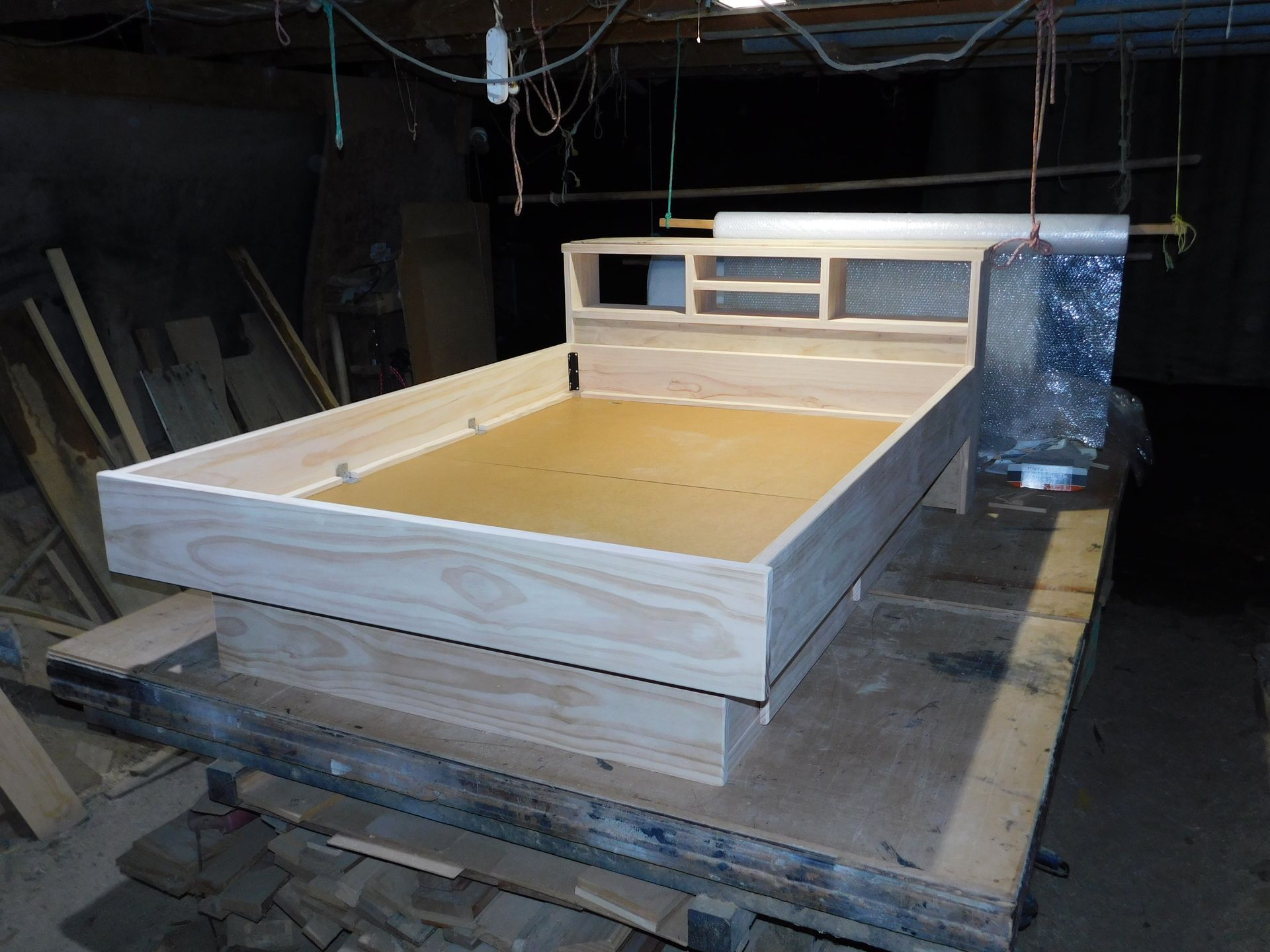 A Wooden Bed Frame with Headboard on A Workbench — Water Works Waterbeds in Chermside, QLD
