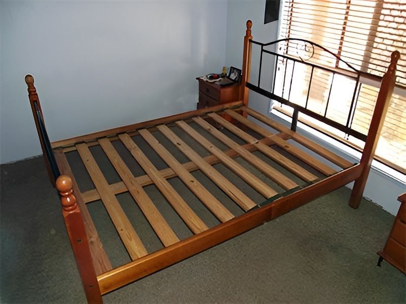 A Wooden Bed Frame with Black Metal Headboard — Water Works Waterbeds in Sunshine Coast, QLD