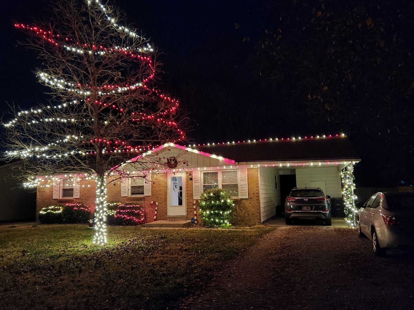 House decorated with red and white Christmas lights at night.