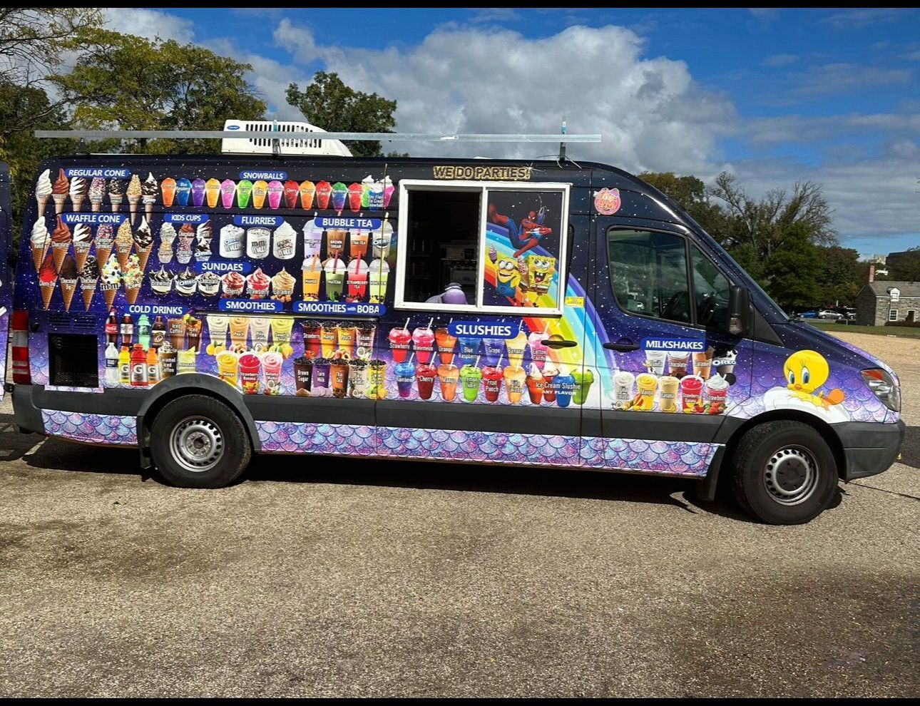 A colorful ice cream truck is parked in a parking lot
