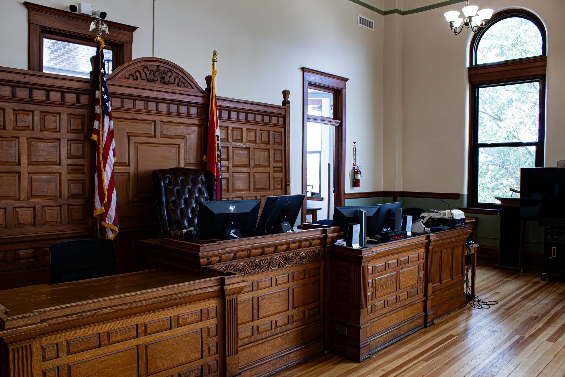 A judge 's bench in a courtroom with a flag on it