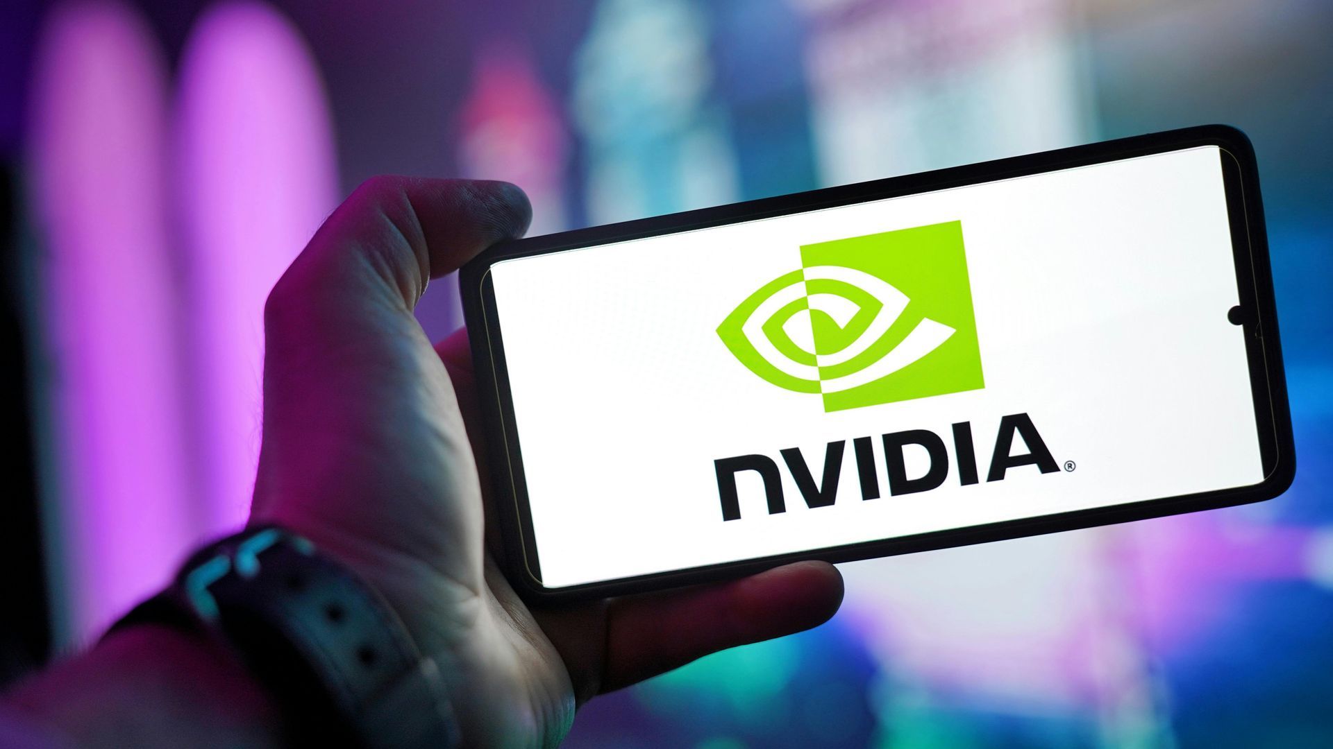 A person is holding a cell phone with the nvidia logo on it