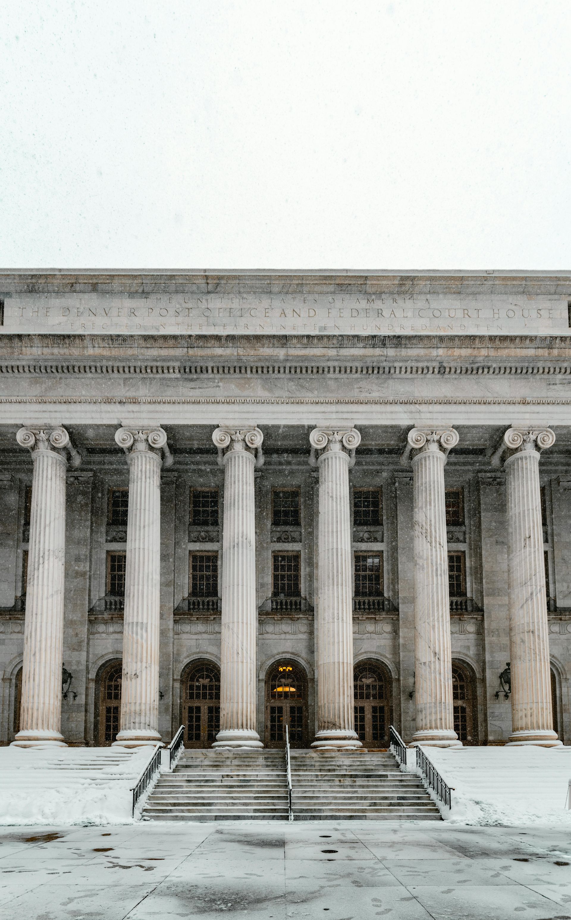 A large building with columns and stairs in the snow