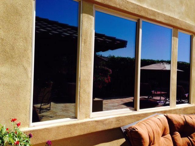 A large window with a brown couch in front of it